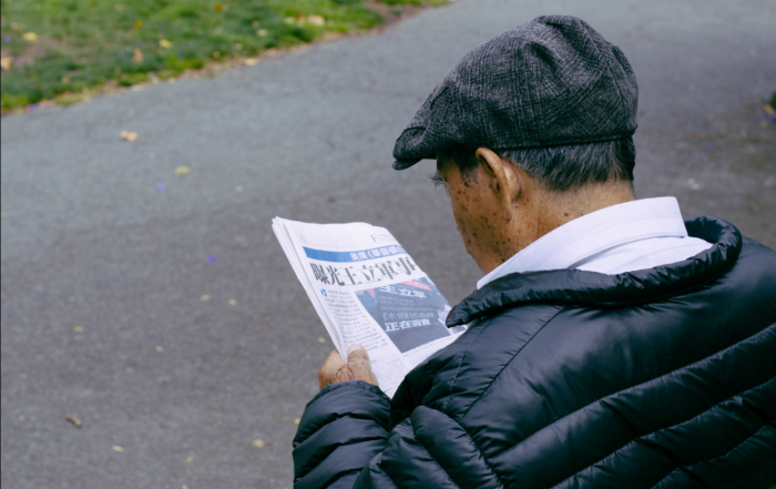 old man reading newspaper