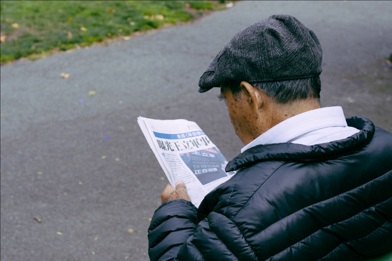 old man reading newspaper